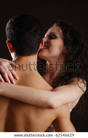 young couple flirting with each other, while the woman is biting the man\'s ear