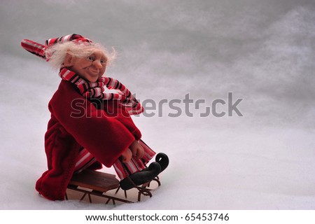 elf riding a sled in the snow.