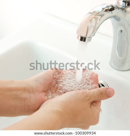 human hands being washed under stream of pure water from tap