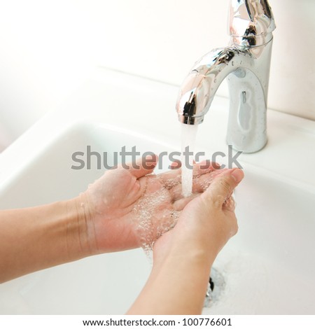 human hands being washed under stream of pure water from tap