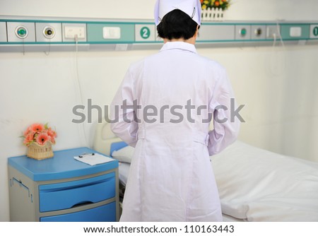 Rear view of  asian nurse caring for patient.