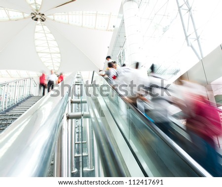 People rush on escalator motion blurred. shopping abstract.
