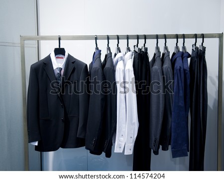 Row of men\'s suits hanging in closet.