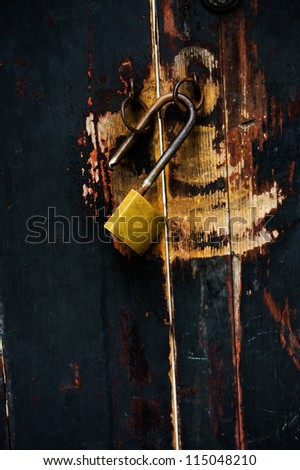 Old lock key on the black wood gates