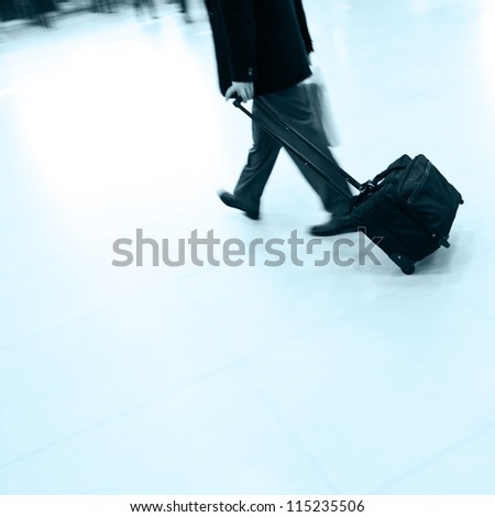 Businessman pulling a trolley luggage at station.
