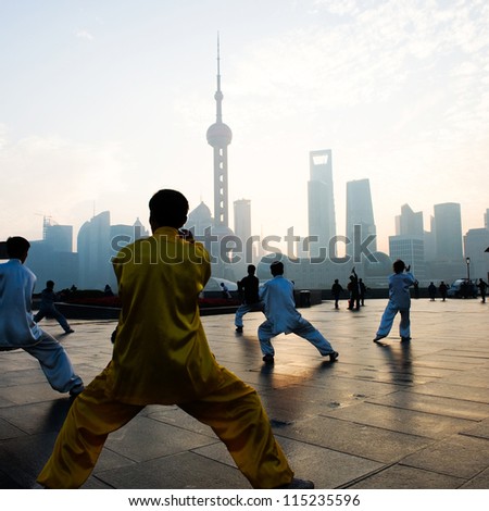 SHANGHAI - NOV. 21:  People practice Taiji on the Bund , Oriental Pearl Tower in the distance, on November 21, 2010 in Shanghai, China.  One of the top ten attractions in Shanghai.