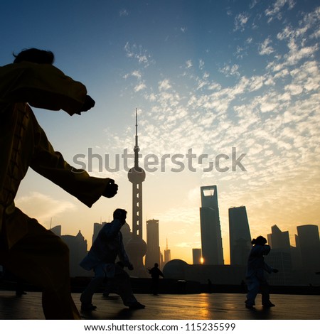SHANGHAI - NOV. 21:  People practice Taiji on the Bund , Oriental Pearl Tower in the distance, on November 21, 2010 in Shanghai, China. One of the top ten attractions in Shanghai.