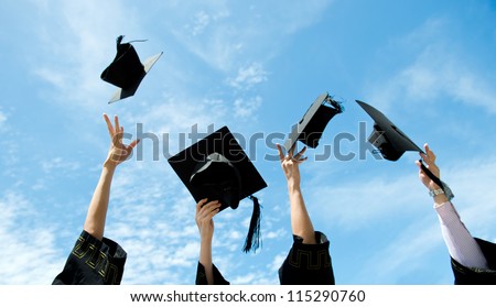 graduates throwing graduation hats in the air.