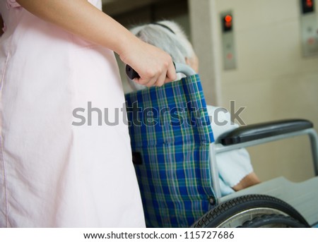 old woman on a wheelchair with assistant
