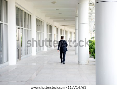 business people walk on the corridor of modern building. rear view