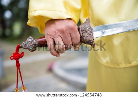 Shot of man holding Chinese sword.