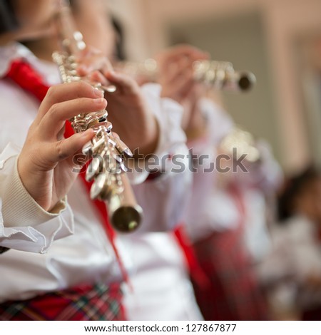 The pupils playing the flute.
