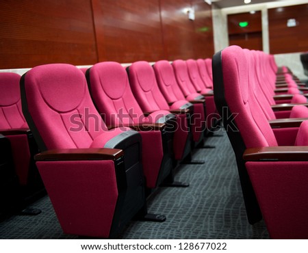 Empty hall for presentation with red armchairs.