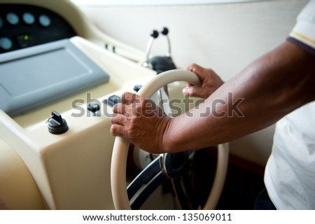 People at the helm of a luxury yacht.