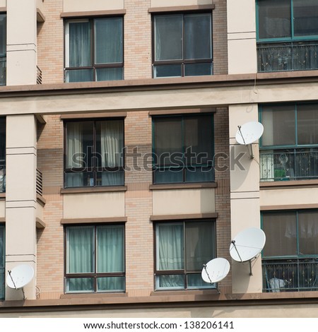 Many satellite dishes on the wall of modern building in shanghai, China.