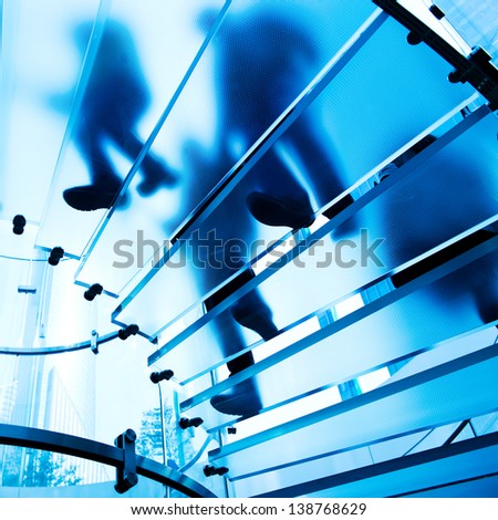 Silhouette people on glass staircase