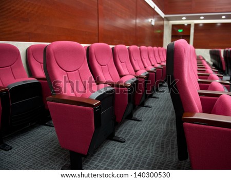 Empty hall for presentation with red armchairs.