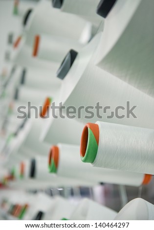Textile industry - yarn spools on spinning machine in a textile factory