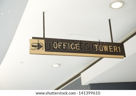 Office Sign Suspended From The Ceiling Of Corridor.
