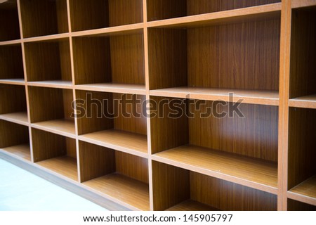 Blank wooden bookshelf in a library.