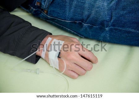 Close up of a iv drip in patient\'s hand.