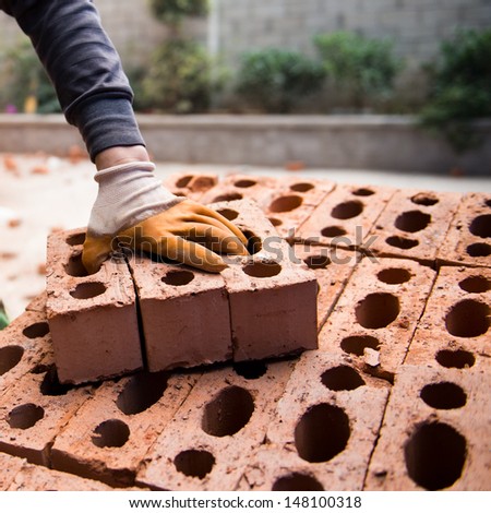 Bricklayer with brick at a construction site.