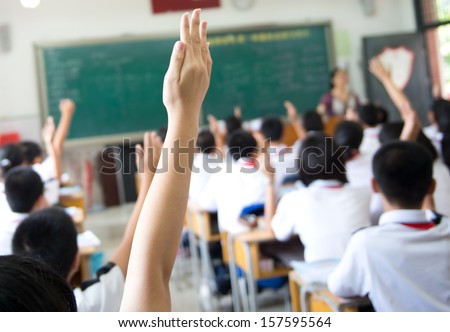 Raised hands in class of middle school.
