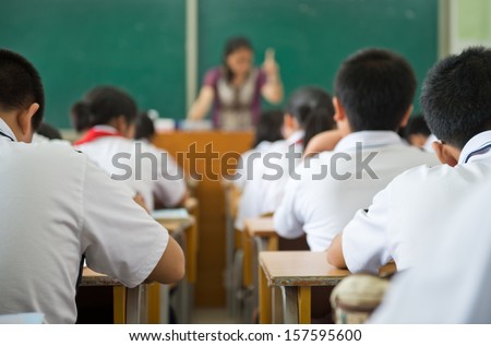group of middle school students studying in classroom