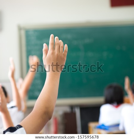 Raised Hands In Class Of Middle School.