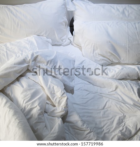 close up of messy bedding sheets and pillow