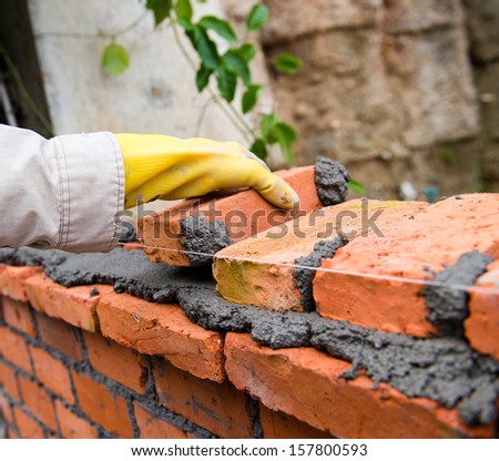 builder laying bricks in site.