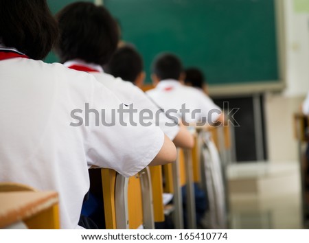 group of middle school students studying in classroom