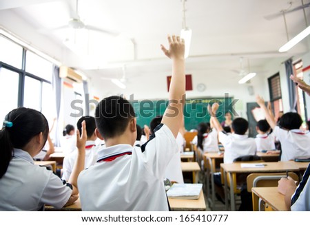 Raised hands in class of middle school.