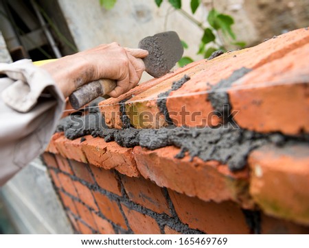 builder laying bricks in site.