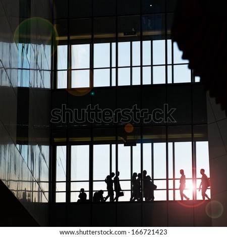 silhouettes of business people rushing at morden office building.