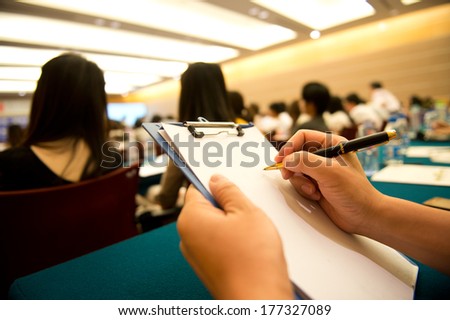 people writing on the document in a business seminar.