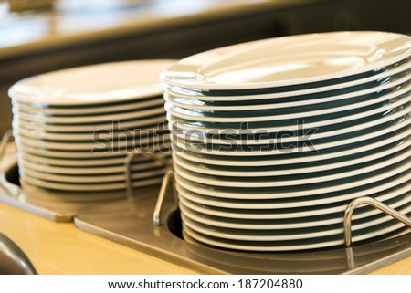 Group of white plates stacked together in a hotel.
