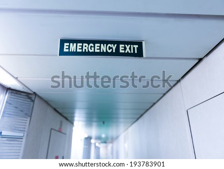 exit sign suspended from the ceiling of cruise ship corridor.