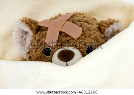 Teddy bear ill in bed