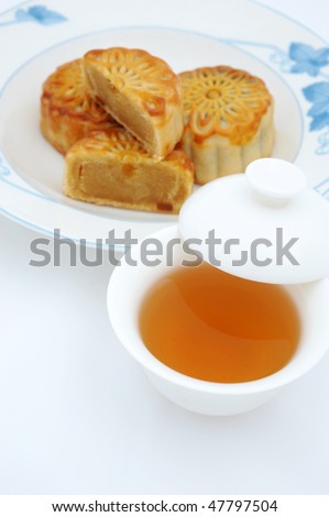 Chinese moon cakes and tea  for Chinese mid-autumn festival. The tea is in focus, and cakes are blurred.