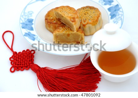 Chinese moon cake, tea and Chinese knot , for Chinese mid-autumn festival. The tea is in focus, and others are blurred.