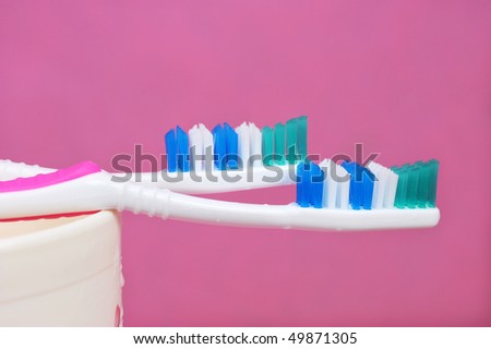 Her toothbrush and his toothbrush on pink background