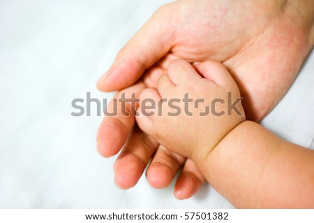 New-born asian baby hand in father's palm.