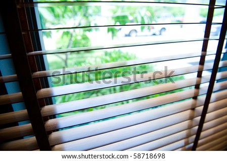 blinds inside a window being opened to show sunlight.