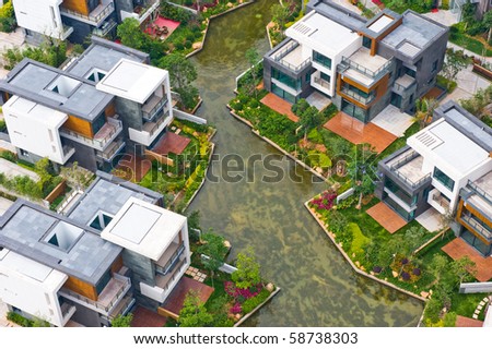 Top view of beautiful villa houses besides water.