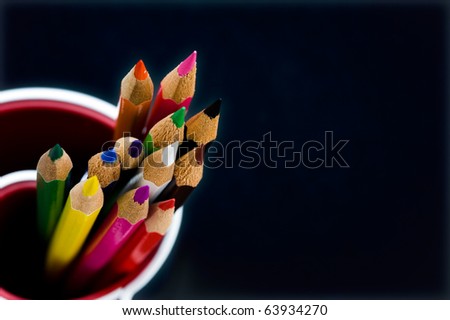 Various Colored Pencils isolated on black background. Macro with extremely shallow depth of field