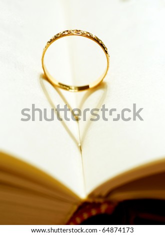 A wedding Ring in the book with shadow of heart shape