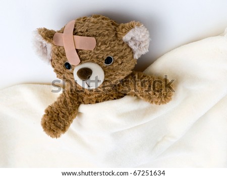 Teddy bear ill in bed