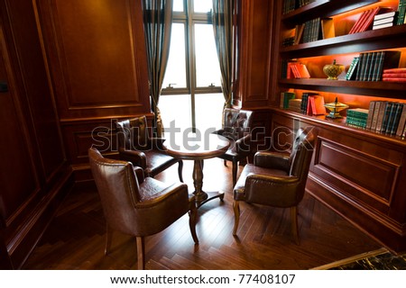 Old studying room with four leather armchairs and wooden table.