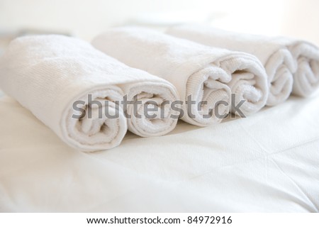 Closeup of soft white towels, rolled and piled.